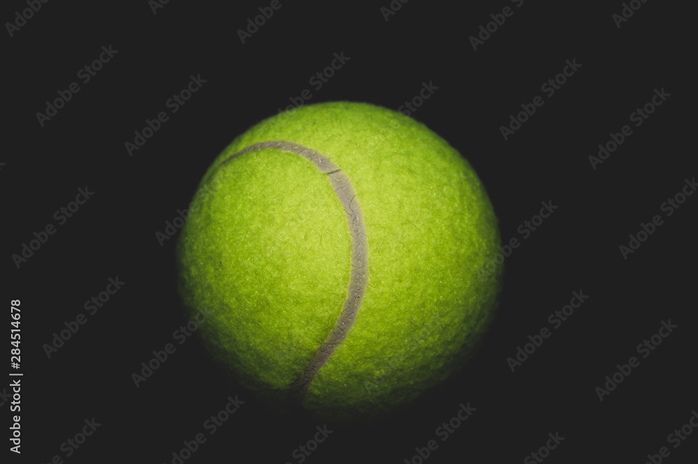 Green tennis ball isolated on black. sport equipment