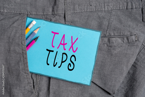 Conceptual hand writing showing Tax Tips. Concept meaning compulsory contribution to state revenue levied by government Writing equipment and blue note paper in pocket of trousers