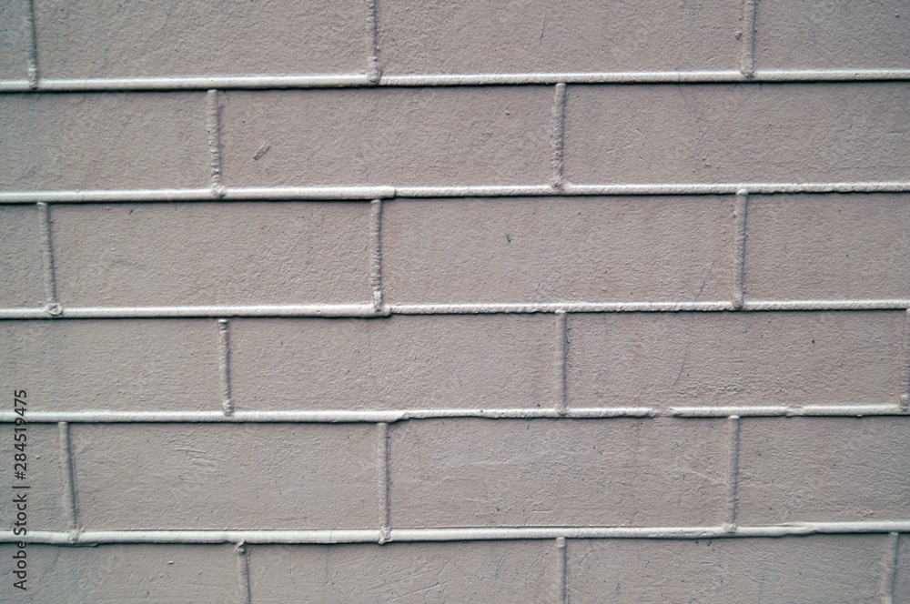 Naklejka premium The wall is made of masonry. Bricks of gray pink color on a front wall.