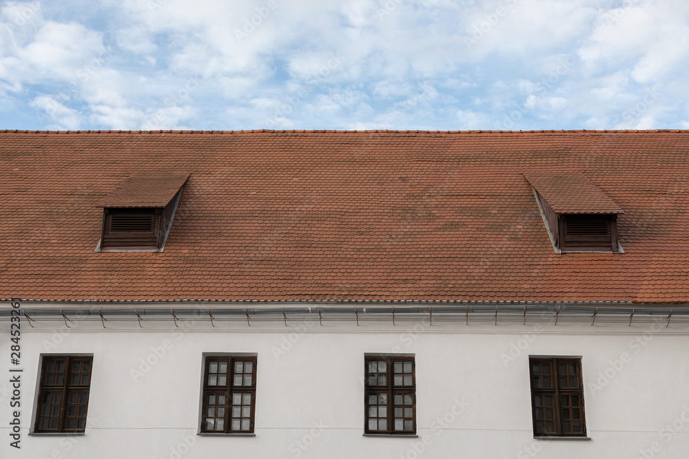 White wall, wooden windows, shingle roof