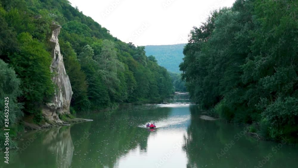 Boat, catamaran sailing on a mountain river between rocks and mountains with amazing views, the concept of outdoor activities, tourism and travel Boat, catamaran sailing on a mountain river between rocks and mountains with amazing views, the concept of outdoor activities, tourism and travel