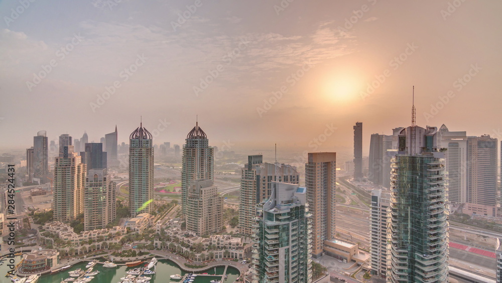 Aerial top view of sunrise in Dubai Marina timelapse. Modern towers and traffic on the road