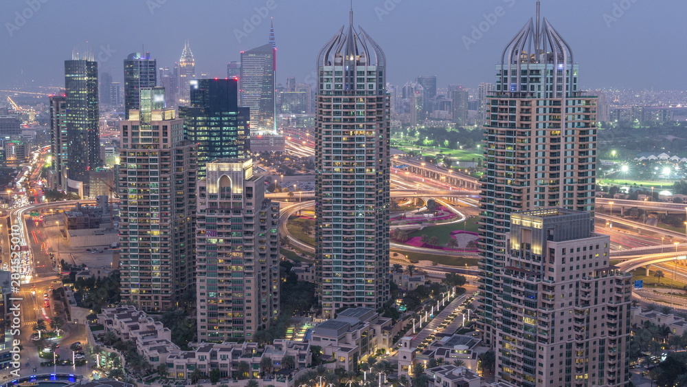 Fototapeta Aerial top view of Dubai Marina day to night timelapse. Modern towers and traffic on the road