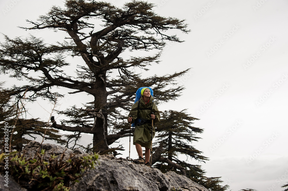 Female hiker in raincoat standing on a mountain