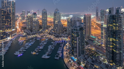 Aerial top view of Dubai Marina day to night timelapse. Modern towers and traffic on the road