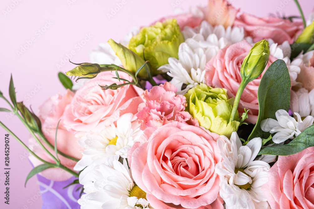 Bouquet of pink roses and white chrysanthemums with green plants, close up