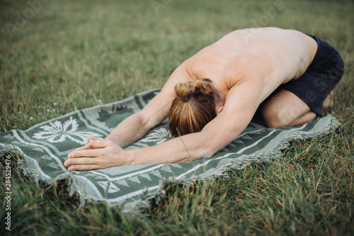 sporty man practicing yoga outdoor photo