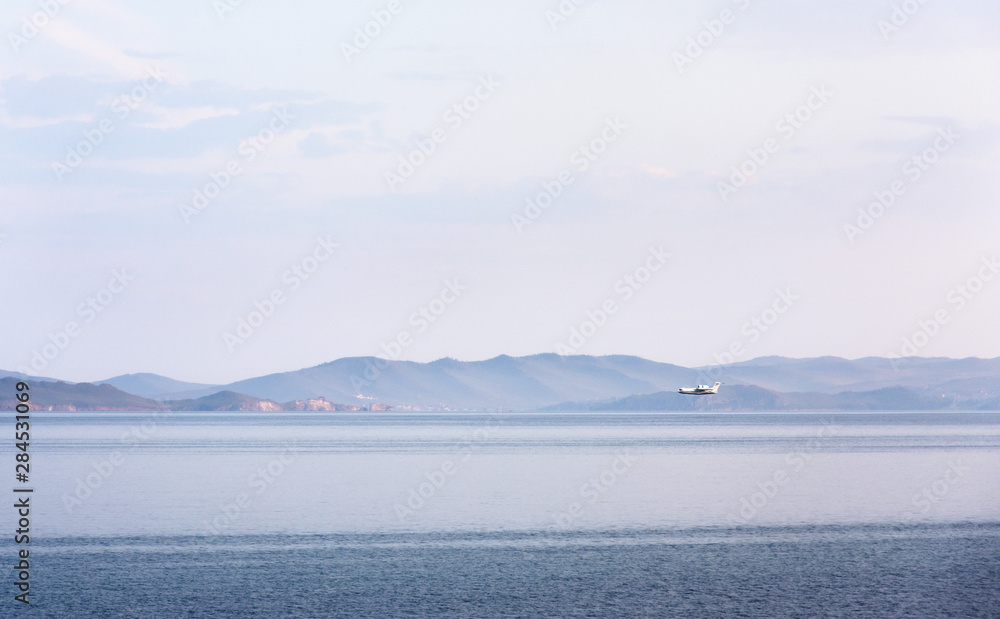 Amphibian aircraft during refueling by water to extinguish forest fires in Irkutsk Region. Lake Baikal, Small Sea Strait