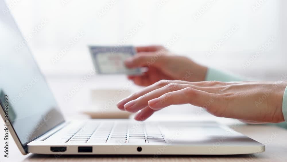 Woman freelancer typing on laptop at home-office. Blurred female hand holding social security number on background. Businesswoman filling out tax return form online at work. Dolly shot Woman freelancer typing on laptop at home-office. Blurred female hand holding social security number on background. Businesswoman filling out tax return form online at work. Dolly shot