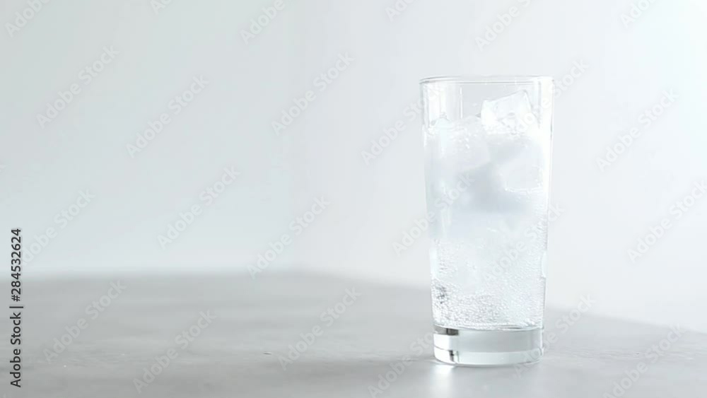 Pouring water in glas with ice cubes Pouring water in glas with ice cubes