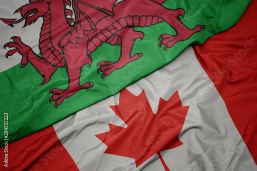 waving colorful flag of canada and national flag of wales.