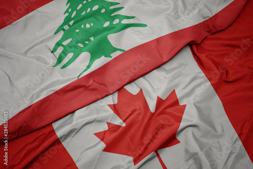 waving colorful flag of canada and national flag of lebanon.