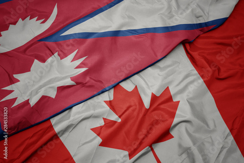 waving colorful flag of canada and national flag of nepal.