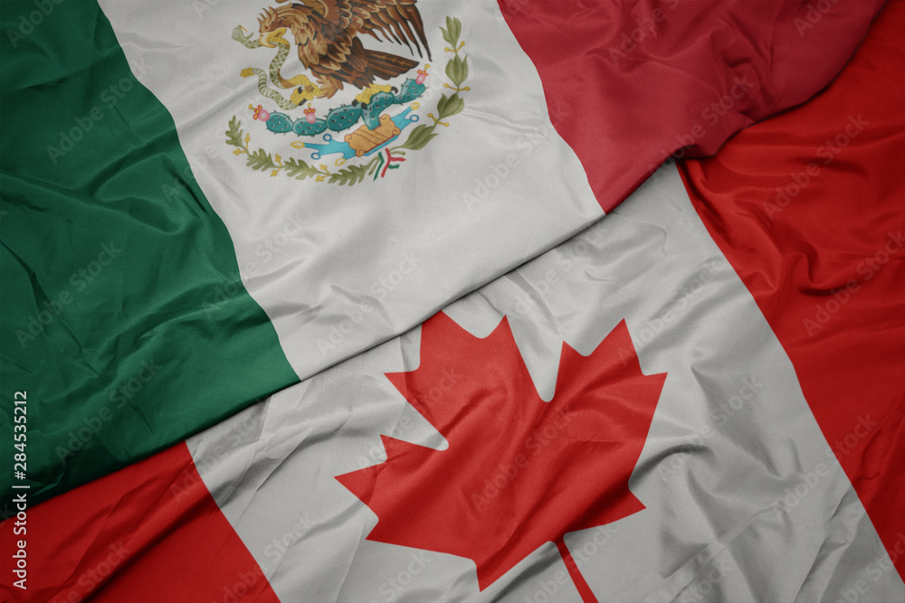waving colorful flag of canada and national flag of mexico. waving colorful flag of canada and national flag of mexico.
