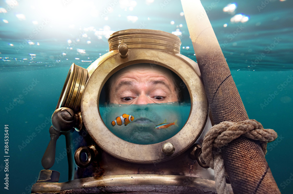 Portrait of man in old diving suit and helmet under water. Funny diver