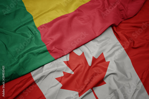 waving colorful flag of canada and national flag of benin.