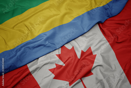 waving colorful flag of canada and national flag of gabon.