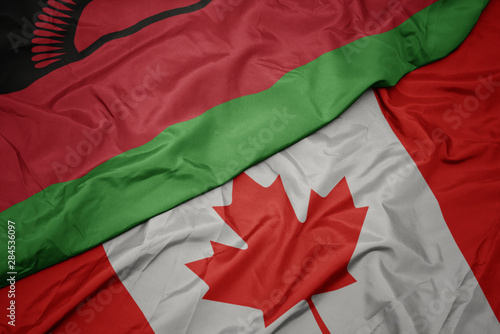 waving colorful flag of canada and national flag of malawi.