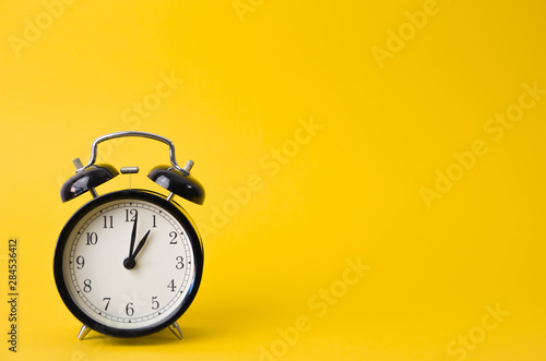 vintage alarm clock on a yellow background