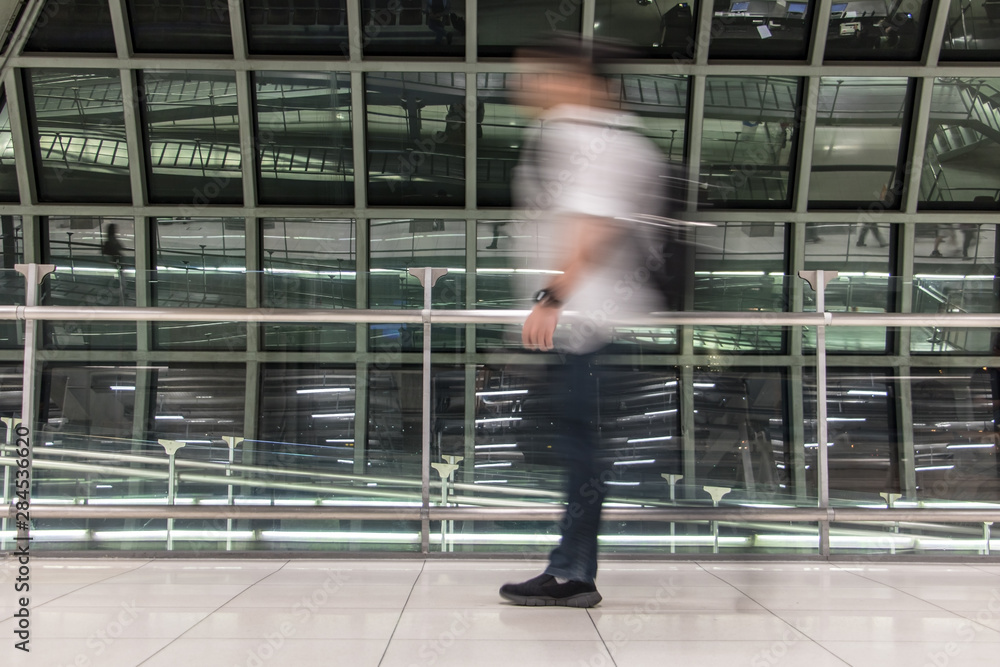 Obraz premium A man walking in blurred motion at airport hall. Abstract image of traveler in the lobby.