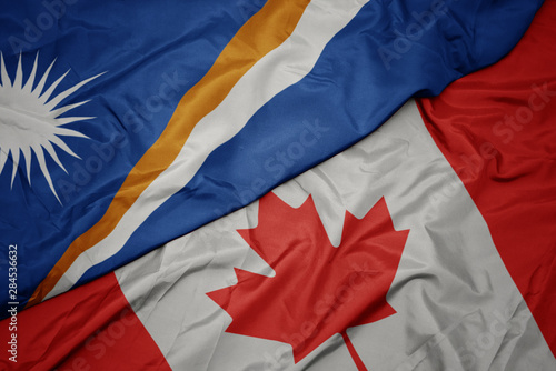 waving colorful flag of canada and national flag of Marshall Islands.