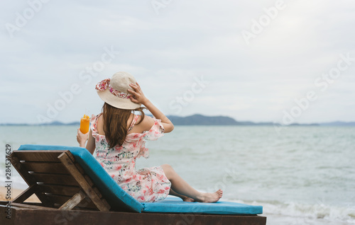 Relax young woman with hat drinking refresh orange cocktail photo