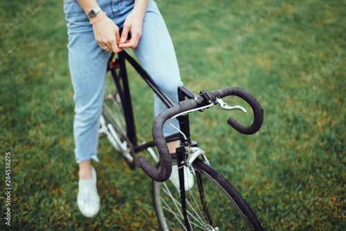 Pretty woman using cycling on the street,outdoor fashion portrait,hipster style ,sunglasses, sneakers,outdoor woman portrait on bike cycle,happy face,close up.spring, sunglasses fashion,cute,emotional