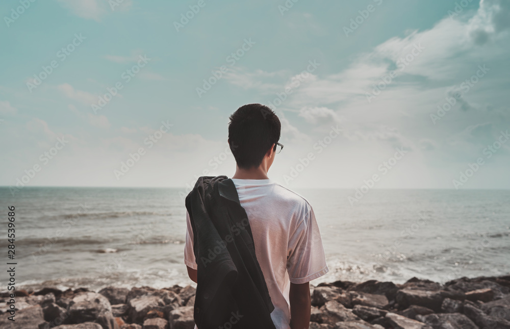 Asian man stand on coast looking sea