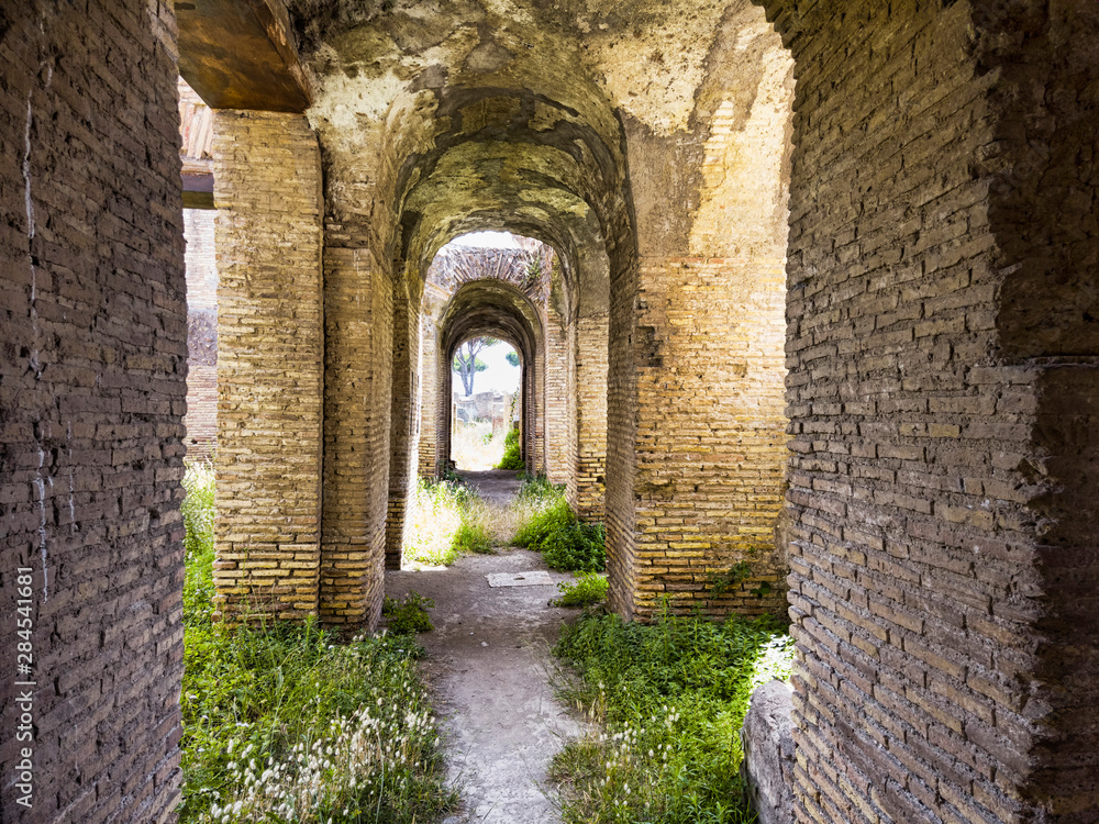 Corridors of the ancient Roman buildings in the archaeological excavations of Ostia Antica, arches and ceilings with stuccoes and well preserved decorations