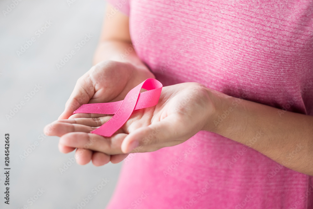 October Breast Cancer Awareness month, Woman in pink T- shirt with hand holding Pink Ribbon for supporting people living and illness. Healthcare, International Women day and World cancer day concept October Breast Cancer Awareness month, Woman in pink T- shirt with hand holding Pink Ribbon for supporting people living and illness. Healthcare, International Women day and World cancer day concept