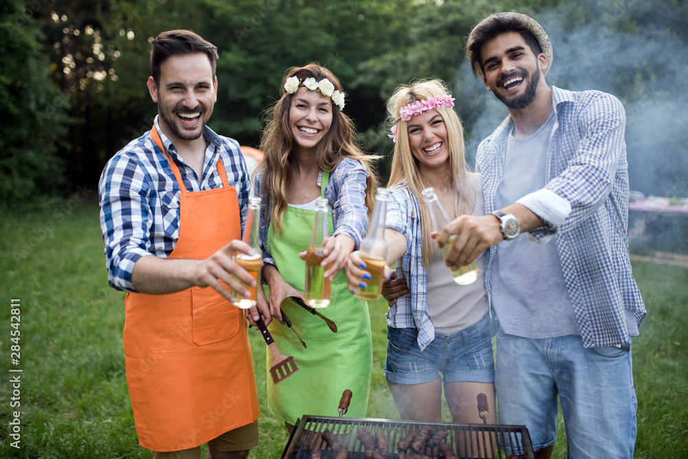 Fototapeta premium Happy group of friends making a barbecue together outdoors in the nature