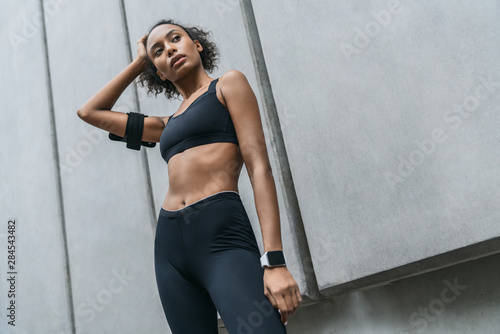 Female athlete looking tired after training on urban street