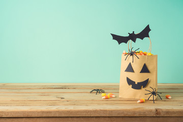 Halloween holiday concept with party gift paper bag decor and candy corn  on wooden table
