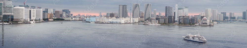 Tokyo tourist seaport with the piers of Takeshiba on the left, of Tsukishima in the center and the Harumi passenger terminal on the right at twilight.