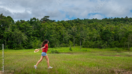 Young asia woman in a green field,enjoying in the sunny summer day.