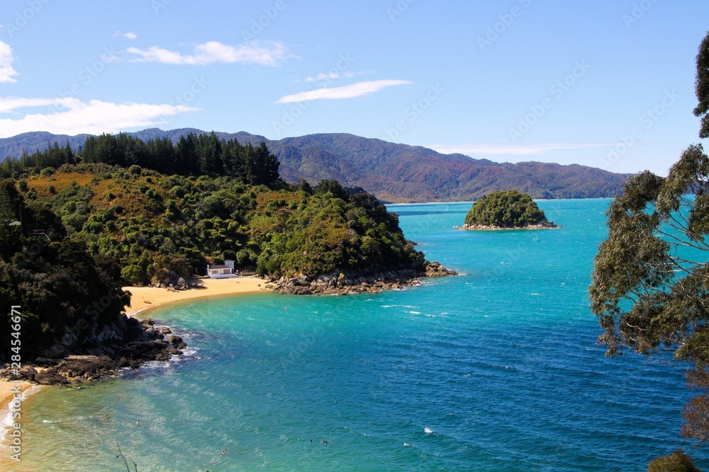 Panoramic view over blue lagoon with small islands and green forest - Abel Tasman national park, New Zealand