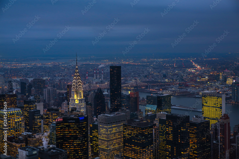 View on New York City skyline at night with manhattan bridge in the back