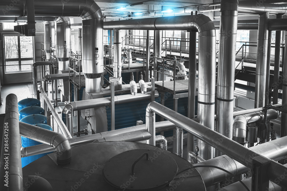 Modern industrial gas boiler room equiped for heating process. Pipelines, valves. View from above. Blue toning Modern industrial gas boiler room equiped for heating process. Pipelines, valves. View from above. Blue toning
