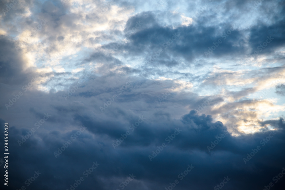CLOSE UP: Dark grey stormy clouds gather above Lake Maggiore on a calm summer evening. Dramatic shot of clouds covering up the colorful sunlit morning sky. Orange hued evening sky and stormy clouds. CLOSE UP: Dark grey stormy clouds gather above Lake Maggiore on a calm summer evening. Dramatic shot of clouds covering up the colorful sunlit morning sky. Orange hued evening sky and stormy clouds.