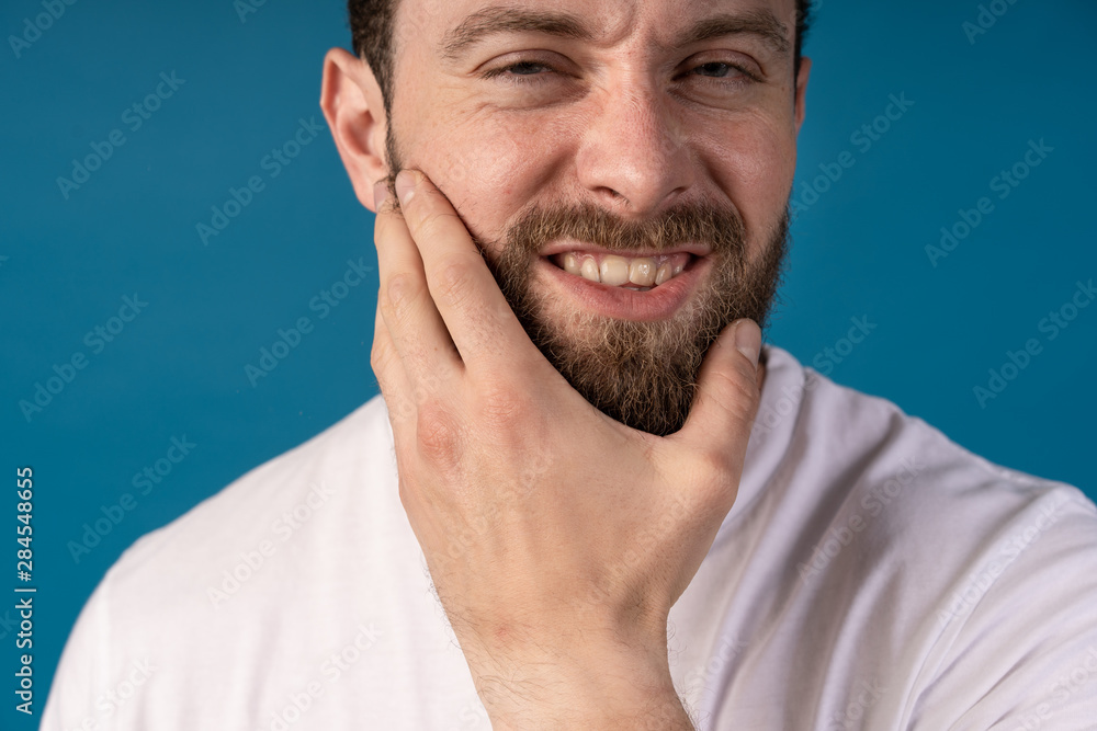 Fototapeta premium Handsome young man while having toothpain. Unhappy face. Harrd toothpain.