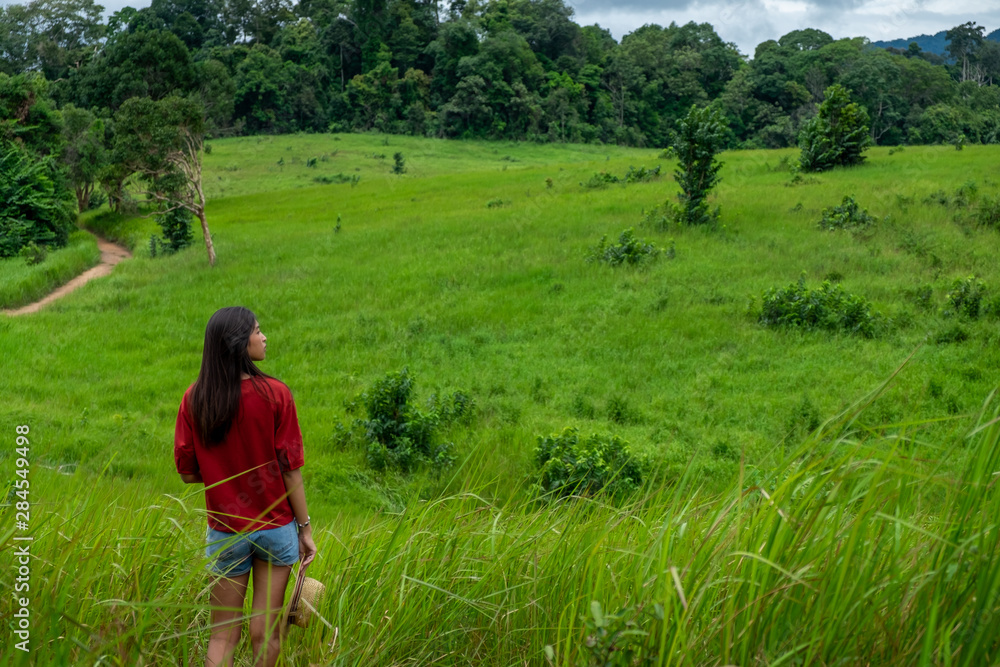 Young asia woman in a green field,enjoying in the sunny summer day.