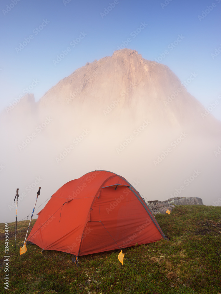 Tourist red tent below Segla Mountain in summer