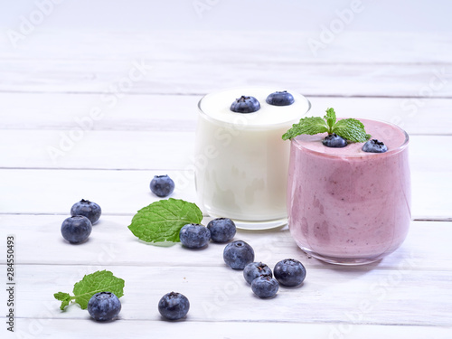 White yogurt and blueberry yogurt on wooden table
