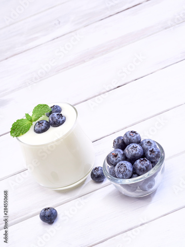 Blueberry yogurt glass on white wooden table