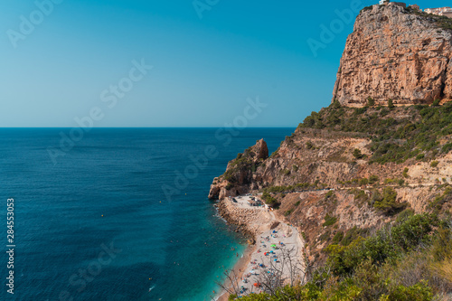 Top view of people at colorful and picturesque Beach lagoon with turquoise water in Javea , Alicante, Spain.