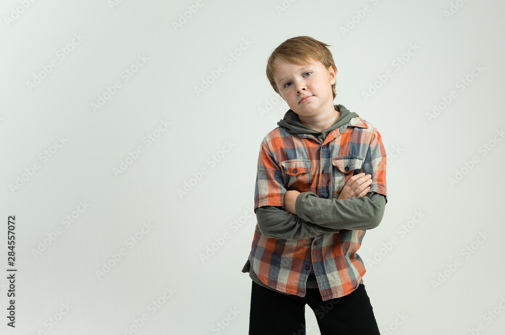 Photo portrait waist-high of a fun cheerful cute happy school-age boy. Rejoices, smiles on a white background. Shows hands. Photo portrait waist-high of a fun cheerful cute happy school-age boy. Rejoices, smiles on a white background. Shows hands.