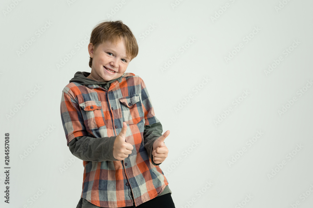 Photo portrait waist-high of a fun cheerful cute happy school-age boy. Rejoices, smiles on a white background. Shows hands. Photo portrait waist-high of a fun cheerful cute happy school-age boy. Rejoices, smiles on a white background. Shows hands.