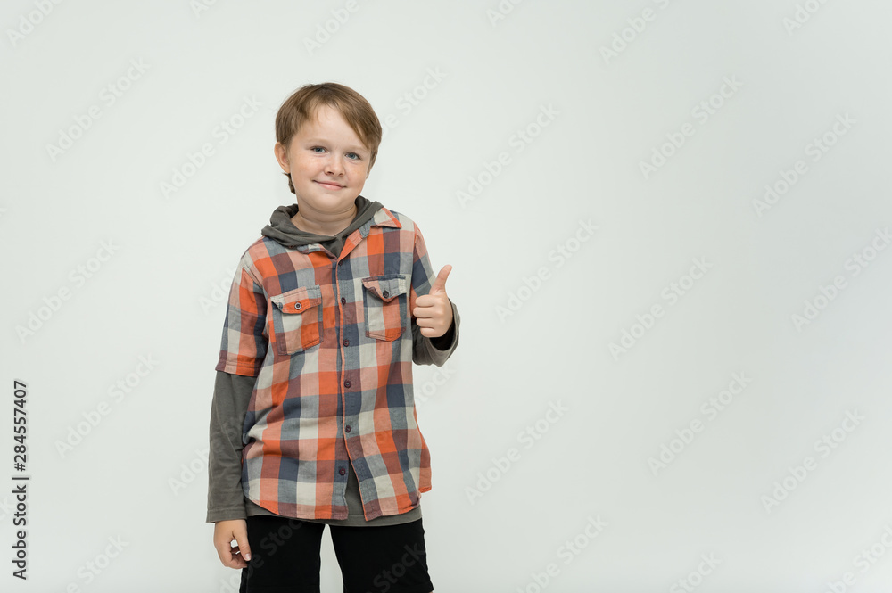 Photo portrait waist-high of a fun cheerful cute happy school-age boy. Rejoices, smiles on a white background. Shows hands. Photo portrait waist-high of a fun cheerful cute happy school-age boy. Rejoices, smiles on a white background. Shows hands.