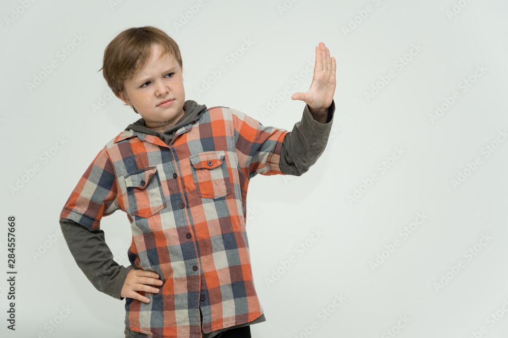 Photo portrait waist-high of a fun cheerful cute happy school-age boy. Rejoices, smiles on a white background. Shows hands. Photo portrait waist-high of a fun cheerful cute happy school-age boy. Rejoices, smiles on a white background. Shows hands.