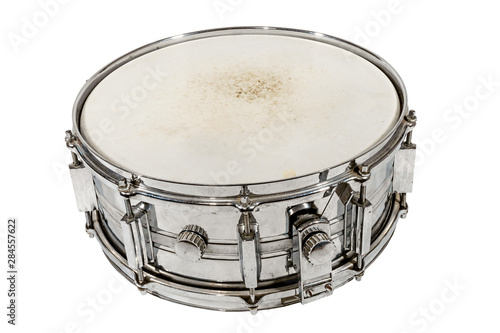 Old silver Snare drum stands on the ground isolated